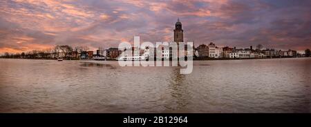 Panoramafoto im Winter der Hansestadt Deventer auf der anderen Seite des Flusses IJssel mit schönem, wolkenfreiem Himmel Stockfoto