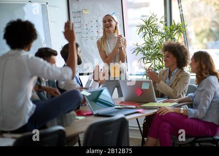 Frau klatscht bei einem Geschäftstreffen die Hände mit ihren Mitarbeitern, Business, Meeting, Casual Briefing Concept Stockfoto
