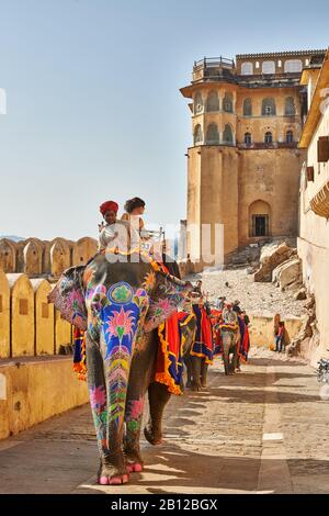 Bunt bemalte indische Elefanten bringen Touristen in das Amer-Fort, Jaipur, Rajasthan, Indien Stockfoto