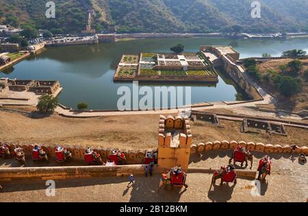 Panoramablick von Amer Fort auf den Maotha See mit Elefanten, die mit Touristen aufsteigen, Jaipur, Rajasthan, Indien Stockfoto