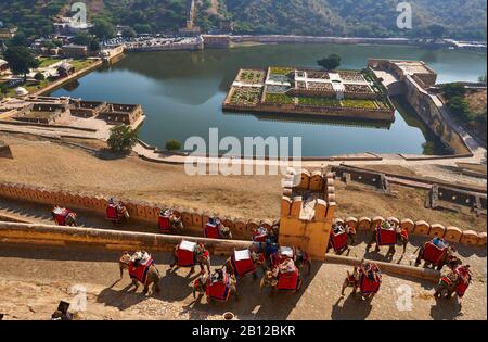 Panoramablick von Amer Fort auf den Maotha See mit Elefanten, die mit Touristen aufsteigen, Jaipur, Rajasthan, Indien Stockfoto