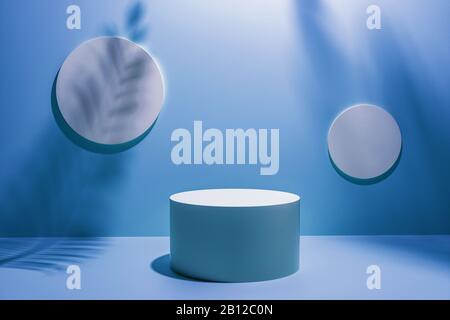 Kreatives Layout aus blauem Studiohintergrund für Produktplatzierung oder Anzeige mit kreisförmigem Sockel vor zwei leeren runden Wandplaketten mit t Stockfoto