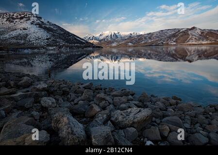 Bergspiegelungen in einem See im Winter. Mt. Timpanogos ist ein ikonischer Berggipfel im Norden Utahs, USA. Sein Bild spiegelt sich in einem See wider. Stockfoto