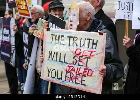 Ein Anhänger des Wikileaks-Gründers Julian Assange, der eine Donald Trump-Gesichtsmaske trägt, hält ein Schild außerhalb des Australia House im Zentrum Londons gegen Assanges Auslieferung in die Vereinigten Staaten, wo er Spionagevorwürfe erheben wird. Die Anhörung zum Auslieferungsverfahren wird am Montag, 24. Februar 2020, vor dem Londoner Crown Court abgehalten. Stockfoto