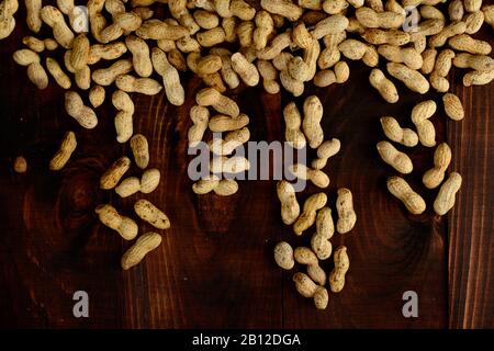 Erdnüsse auf dunklem Hintergrund. Erdnüsse in einer Schale. Gesunde Ernährung. Stockfoto