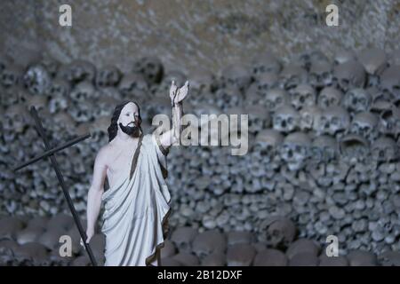 Statue des Jesus vor den Schädeln der Opfer - die Plage von 1656 und die Cholera-Epidemie im Jahr 1836, Cimitero delle Fontanelle, Sanità-Bezirk Neapel Italien Stockfoto