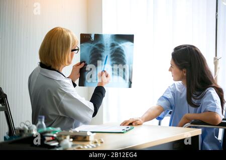 Frauen Arzt erklärt Röntgenergebnis für Patientinnen Stockfoto