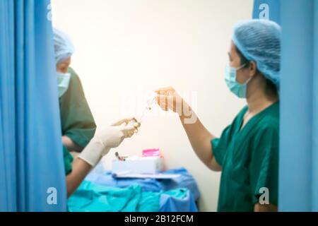 Verschwommenes Bild von Chirurgenteams, die Operationen in steriler Umgebung des Krankenhauses durchführen, oder Gruppe von Chirurgen im Operationssaal mit chirurgischen Geräten. Stockfoto