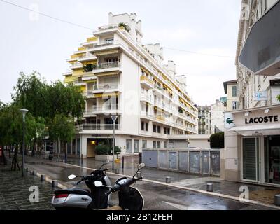 Nice, Frankreich - 24. November 2019: Ruhiges Viertel im Zentrum von Nizza mit hohen Apartmentgebäuden im Südstil und Lacoste Kleidermode-Shop Stockfoto