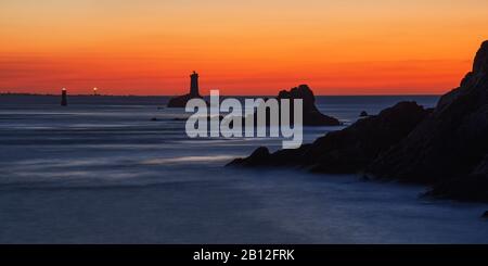 Spiel der Farben Blau und Orange mit Leuchtturm, Point du Raz, Finistere, Frankreich Stockfoto