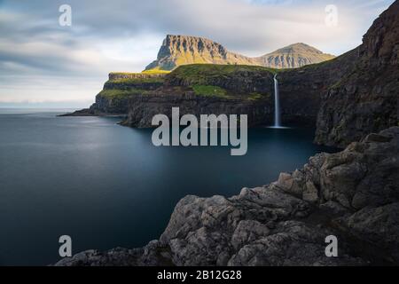 Morgenstimmung an der Steilküste mit Wasserfall in Gásadalur, Vágar, Färöer, Dänemark Stockfoto