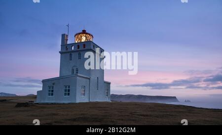 Morgen rot über isländische Leuchtturm an der Südküste, Dyrholaey, Island Stockfoto