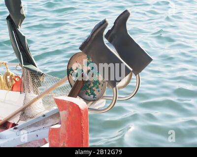 Trocknen von wellington-stiefeln vor einem farbenfrohen griechischen Fischerboot Maria bei Agios Georgios Lichados, Evia, Griechenland. Stockfoto