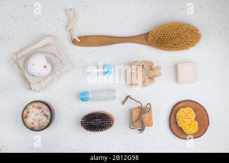 Badzubehör, Seifen, Körperbürste, Schrubben mit Rosenblättern, Flaschen für Kosmetik, Schwamm auf weißem Hintergrund, Draufsicht, Nahaufnahme. Spa-Konzept Stockfoto