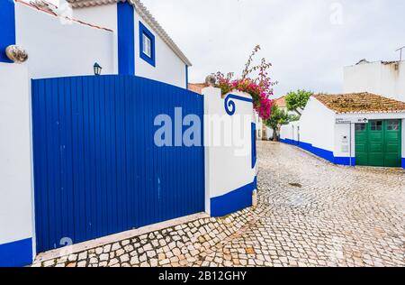Blick auf die Straßen von Ericeira, traditionelle weiße Häuser mit blauen Streifen, Portugal Stockfoto