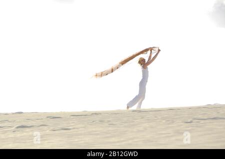 Frau, die ein rotes transparentes Tuch in der Brise hält, Dunes, Corralejo, Fuerteventura, Kanarische Inseln, Spanien, Europa Stockfoto