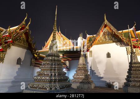 Turmspitzen des Wat Pho oder Wat Phra Chetuphon Buddhist Temple Complex, auch bekannt als Tempel des Sich Zurücksetzenden Buddha, in Bangkok Thailand bei Nacht Stockfoto