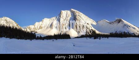 Weite Panoramalandschaft Winter Schnee Bedeckt Alpine Wiese Weit Entfernte Schneebedeckte Berggipfel am Horizont. Kananaskis Country, Canadian Rockies, Alberta Stockfoto