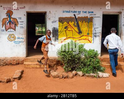 Ein Schüler, der abtritt, und ein Lehrer, der in die Klassenzimmer einer ländlichen Junior School in der Nähe Von Voi im Süden Kenias eindringt Stockfoto