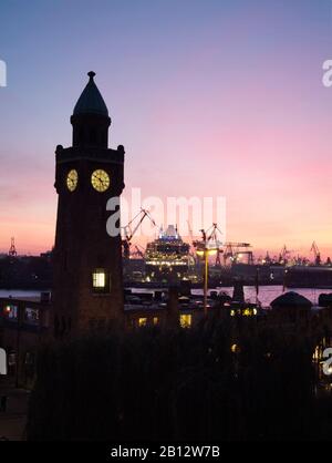 Silhouette der Landungsbrücken mit Passagierschiff Queen Mary 2 in Werften, Hamburg, Deutschland Stockfoto