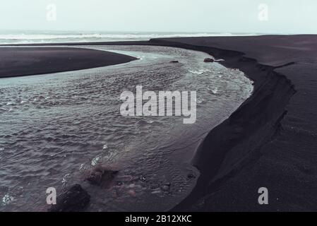 Der schwarze Sand an der Südküste Islands bei Solheimasandur bei Vik, an einem launigen Wintermorgen. Stockfoto
