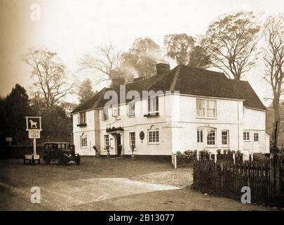 C vierziger Jahre - Ein altes Foto des Weißen Pferdes in Hertingfordbury, Hertfordshire, England. Obwohl Der Hostelschmuck der Kategorie II aus dem 15. Jahrhundert 2016 geschlossen wurde, ist die Kneipe nach der Renovierung wieder in Betrieb. Ein Schild (auf Rädern) steht außerhalb der Werbeteas. Stockfoto