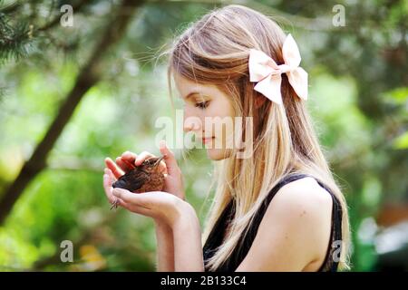 Mädchen mit Jungvogel in der Hand Stockfoto