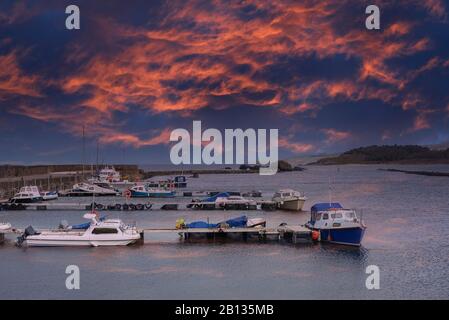 Der Hafen von Mather Maidens in der Nähe von Girvan in Schottland. In South Ayrshire liegt es ein kleines Fischerdorf, das der örtlichen Gemeinde dient. Die Sonne geht über Stockfoto