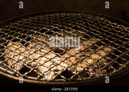 Runder Metallgitter auf dem Holzkohlenofen im traditionellen koreanischen Stil. Stockfoto