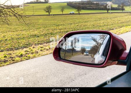 Landschaft im Spiegel eines Autos. Bild Landschaft am Seitenspiegel, Konzept Reisen. Blick auf die Fahrzeugscheibe am Rückspiegel Stockfoto