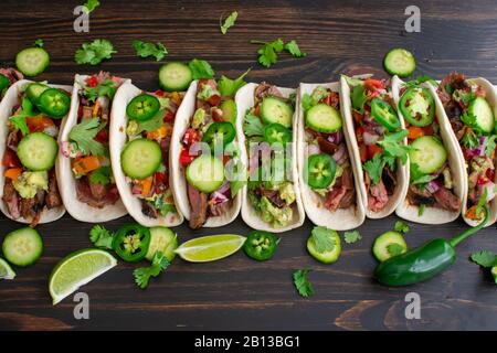 Gegrillte Flanke Steak Tacos mit Guacamole und Pico de Gallo: Rindfleisch Tacos in Mehltortillas mit Cilantro, Gurke und jalapeños Stockfoto