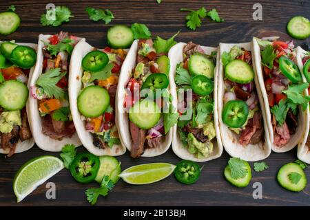 Gegrillte Flanke Steak Tacos mit Guacamole und Pico de Gallo: Rindfleisch Tacos in Mehltortillas mit Cilantro, Gurke und jalapeños Stockfoto