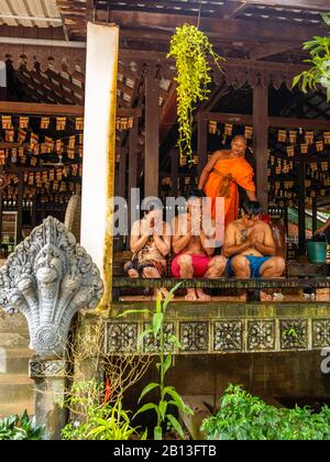 Drei Menschen erhalten während des Wasserfestes einen Wassersegnung von einem Mönch in einem buddhistischen Tempel in Kambodscha. Angkor Wat Archäologischer Park, Siem Reap, C. Stockfoto