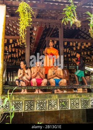 Drei Menschen erhalten während des Wasserfestes einen Wassersegnung von einem Mönch in einem buddhistischen Tempel in Kambodscha. Angkor Wat Archäologischer Park, Siem Reap, C. Stockfoto