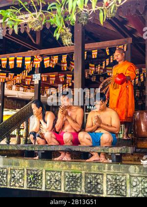 Drei Menschen erhalten während des Wasserfestes einen Wassersegnung von einem Mönch in einem buddhistischen Tempel in Kambodscha. Angkor Wat Archäologischer Park, Siem Reap, C. Stockfoto