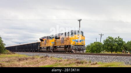 San ANTONIO, TX - 4. JUNI 2019 - Elektrolokomotiven der gelben Union Pacific mit Kies-/Zughintergrund Stockfoto