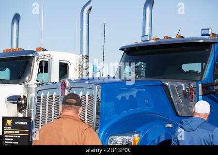 Zwei Männer, die auf der Oregon Logging Conference in Eugene, Oregon, USA, neue Kenworth-Halbzeuge betrachten. Stockfoto