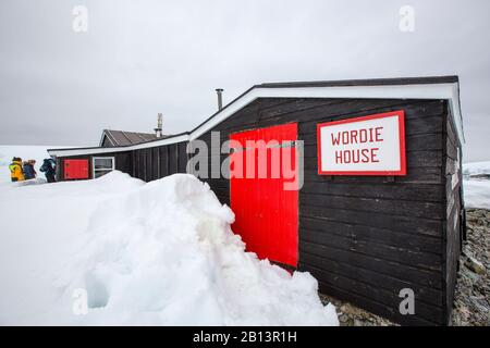 Touristen von einem Expeditionskreuzschiff, das das Wordie House in der wissenschaftlichen Forschungsbasis der alten Briten auf der Winterinsel auf den Argentinischen Inseln Angar besucht Stockfoto