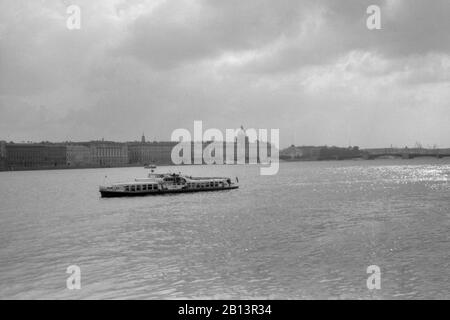 Etwa 1980. Blick vom Newa-Fluss im Hermitage-Museum und im Winterpalast in Leningrad (Sankt Petersburg). Vergnügungsboot mit Touristen, die auf dem Newa-Fluss segeln Stockfoto