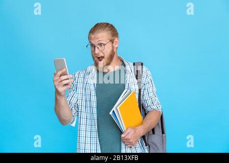Bärtige Studentenbrille weckt Emotionen halten modernes Smartphone Textnachricht lesen Stockfoto