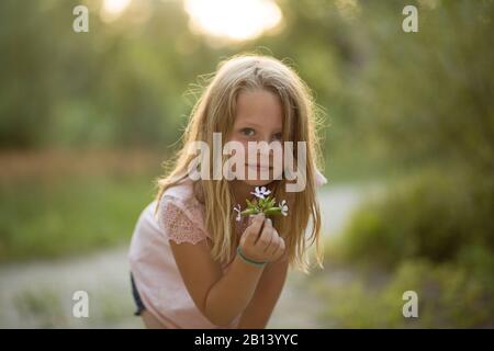 Kleines Mädchen mit Blumenstrauß in den Wald Stockfoto