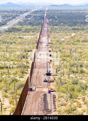 Detailaufnahme der Absperrung und der angrenzenden Versorgungsstraße. Blick nach Westen, auf halber Strecke auf dem Monument Mountain. Barriere tritt in den Horizont zurück. Das Projekt Tucson 2 erstreckt sich über 8 km in der Nähe von Douglas AZ, 11. Februar 2020. Das U.S. Army Corps of Engineers, South Pacific Border District, erbringt vertragliche Dienstleistungen, einschließlich Design- und Bauaufsicht, von Verteidigungsministerium finanzierte Projekte der Südwestgrenze in Kalifornien, Arizona, New Mexico und Texas auf Anweisung der Verwaltung und auf Anfrage des Department of Homeland Security, Zoll- und Grenzschutz. (Niemand in Thi Stockfoto