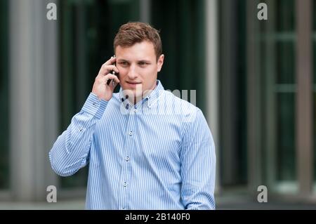 Der junge Mann spricht auf dem Handy Stockfoto