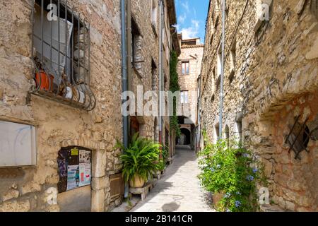 Eine der malerischen engen und überdachten Straßen von Häusern und Geschäften im mittelalterlichen Dorf Tourrettes-Sur-Loup, Stockfoto