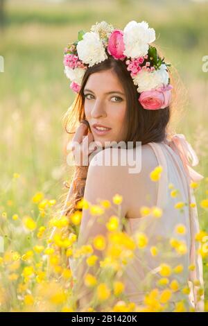 Frau mit Blumen Kranz auf einer Wiese Stockfoto