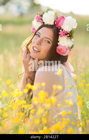 Frau mit Blumen Kranz auf einer Wiese Stockfoto