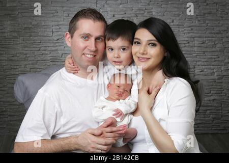 Glückliche Eltern mit Sohn und neugeborenem Baby Stockfoto