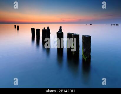 Sonnenuntergang am Weststrand, Steinpyramiden an alter Groyne, Darß, Ostsee, Mecklenburg-Vorpommern, Deutschland Stockfoto