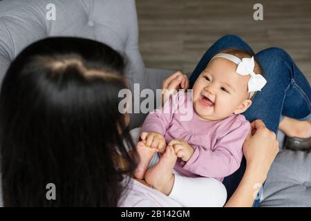 Mutter sitzt mit Baby auf einem Stuhl Stockfoto