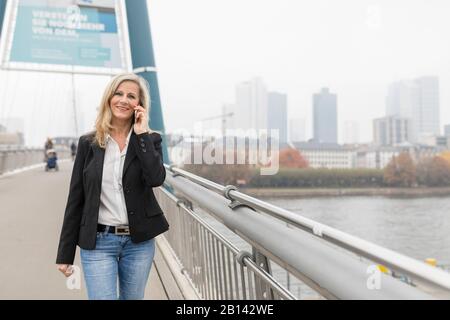 Geschäftsfrau telefoniert auf einer Brücke Stockfoto